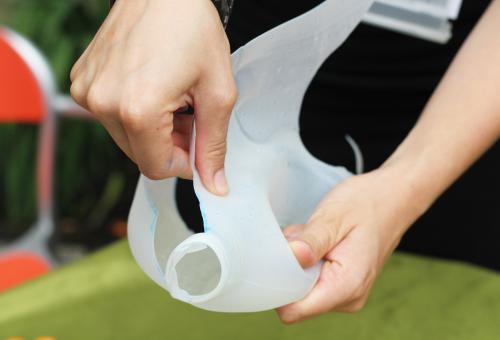 Two hands bending a milk carton
